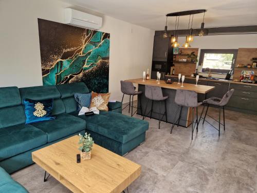 克尔克Villa Porta Krk的一间带绿色沙发的客厅和一间厨房
