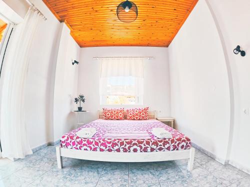 新马尔马拉斯House Charistos的一间卧室设有一张带木制天花板的大床