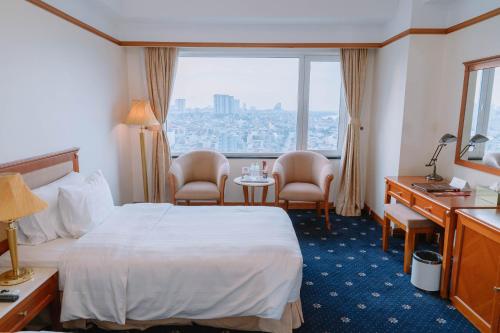 河内A25 Luxury Hotel的酒店客房带一张床、一张桌子和椅子