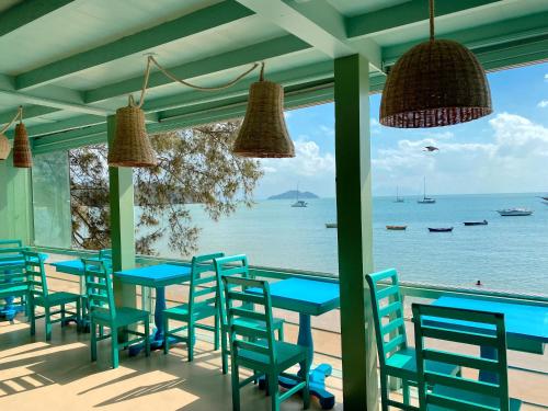 布希奥斯Bamboo Búzios Hostel的一间设有蓝色桌椅的海洋餐厅