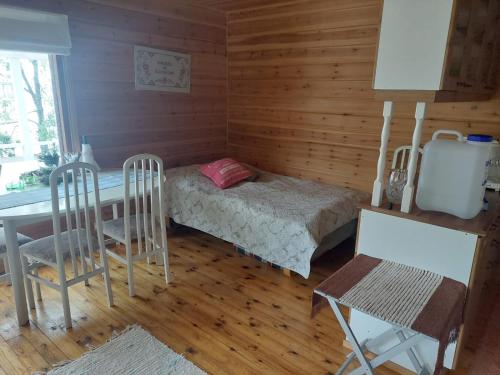 Lakeside Lea, rantamökki的小房间设有一张床、一张桌子和椅子