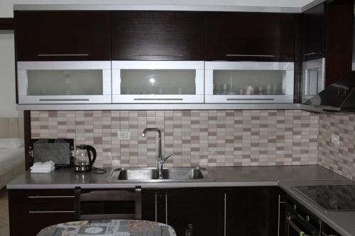 博尔什Cheerful 3-Bedroom Private Villa in Borsh!的厨房配有黑色橱柜和水槽