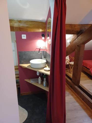 第戎2 chambres privées au calme à la Maison des Bambous的一间带水槽和红色窗帘的浴室
