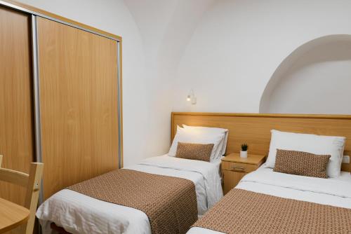 耶路撒冷William's Guest House的小房间设有两张床和一张桌子
