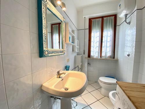 圣温琴佐Appartamento il Leccio的一间带水槽、卫生间和镜子的浴室