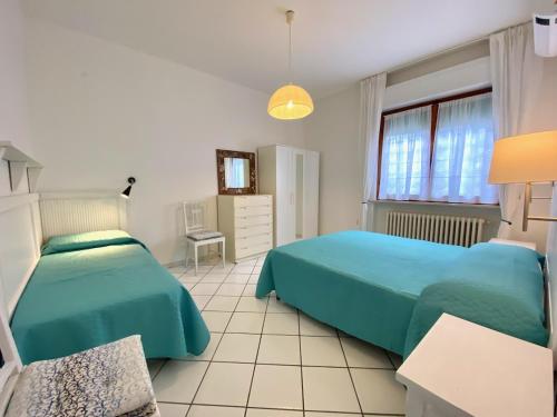 圣温琴佐Appartamento il Leccio的一间卧室设有两张床和窗户。