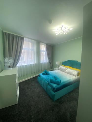 布莱克浦Jackson Holiday Apartments的一间卧室设有蓝色的床和窗户。