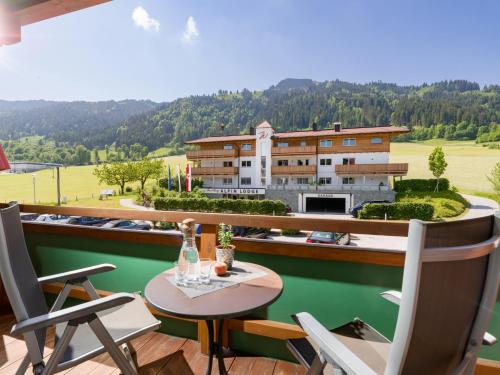 涅德劳Hotel & Alpin Lodge Der Wastlhof的一个带桌椅的阳台和一座建筑