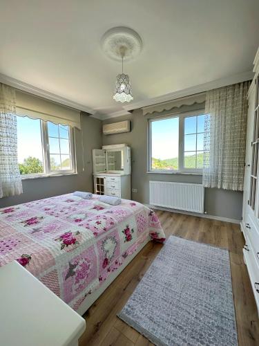 特拉布宗COUNTRY HOME的一间卧室设有一张床和两个窗户。