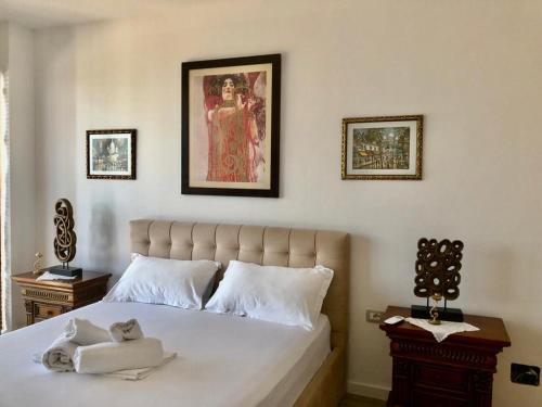 德尔米Rahoni Park & Suites的卧室配有一张床,墙上挂有绘画作品