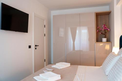 北马马亚-讷沃达里Valleta Sea View Infinity Beach Pool&Spa的一间卧室配有一张床,墙上配有电视