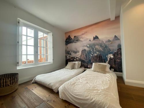 巴约讷Loft Cathédrale的卧室内的两张床,墙上有绘画作品