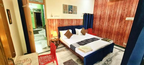阿格拉安努科姆帕宾馆的一间卧室配有一张床和一张红色椅子