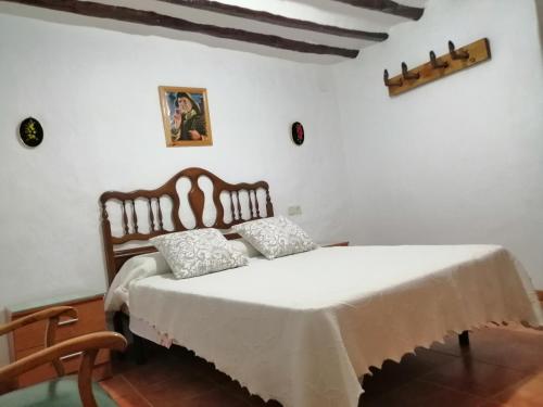 SilesALOJAMIENTO RURAL SILESNATURA的一间卧室配有一张带白色床单和椅子的床