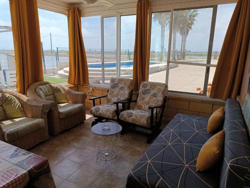 代尔特布雷Mas Panoli的带沙发和椅子的客厅以及大窗户。