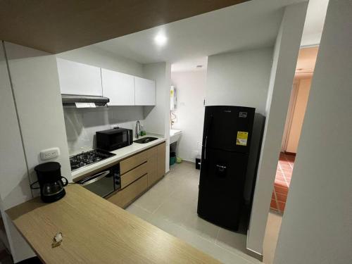 马尼萨莱斯Hermoso apartamento la Francia 3 habitaciones的厨房配有黑色冰箱和炉灶。