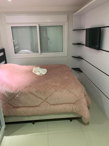 卡内拉Apartamento Gramado/Canela的卧室配有粉红色的床和窗户。