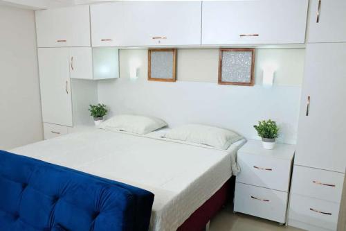 马瑙斯Tropical Executive 1305 with VIEW的卧室配有白色的床和蓝色椅子