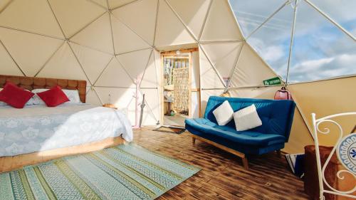 瓜塔维塔Andes Glamping的帐篷内的房间,配有一张床和椅子