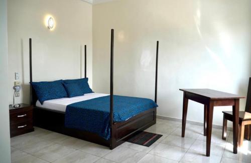 科托努Résidence des Amazones Appartement 2的一间卧室配有一张床和一张木桌