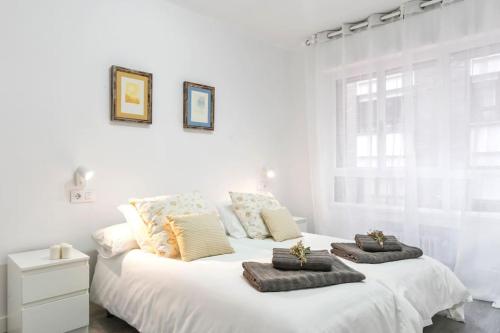希洪Apartamento Marqués de Urquijo的一张白色的床,上面有两个枕头