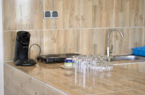 科托努Résidence des Amazones Appartement 2的坐在厨房柜台上的一束酒杯