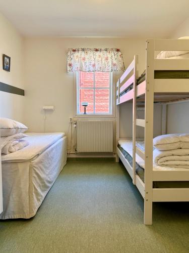 林雪平Valla Vandrarhem的一间卧室设有两张双层床和一扇窗户。