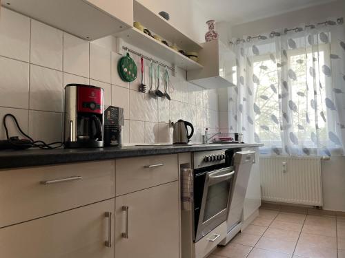 马格德堡Sueños Apartment的厨房配有水槽和炉灶 顶部烤箱