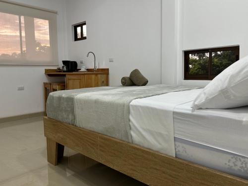 托尔图格罗Tuanis Guest House的一间卧室配有一张带白色床单的大床