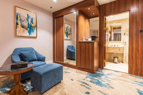 塔伊夫فندق رويال دايموند الطائف的客厅配有蓝色椅子和桌子