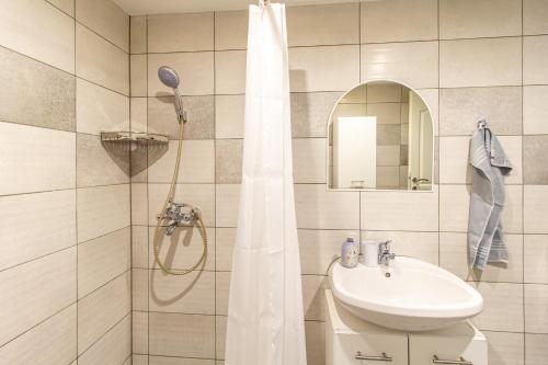 杰尔Déli Terasz A Apartman Free parking, self-check-in anytime的浴室配有淋浴帘和盥洗盆。