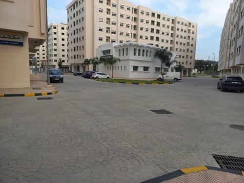 丹吉尔Rawan Appart的停车场,停车场的汽车停在大楼前