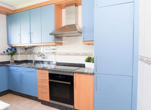 菲尼斯特雷VelayLi - Apartamento en el centro de Finisterre的厨房配有蓝色橱柜和黑炉