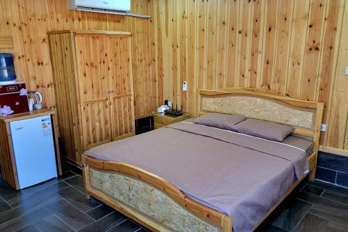 杰拉什atoom lodge的木制客房内的一间卧室,配有一张床