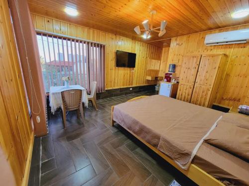 杰拉什atoom lodge的一间卧室配有一张床、一张桌子和一台电视