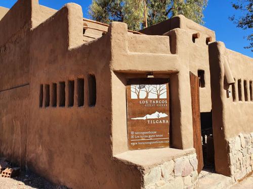 蒂尔卡拉Los tarcos Guest House TILCARA LOFT的沙漠中的一座建筑物,上面有标志