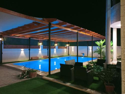 杰里科Al bader villa的游泳池在晚上的凉棚下