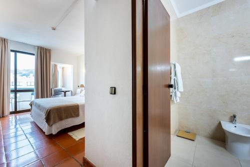 塞勒玛萨勒玛居家酒店的一间卧室配有一张床,浴室设有水槽
