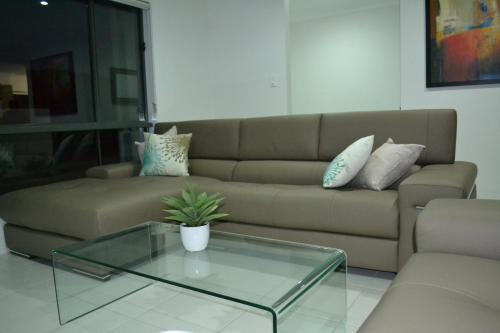 Biloela潶文比洛公寓的带沙发和玻璃茶几的客厅