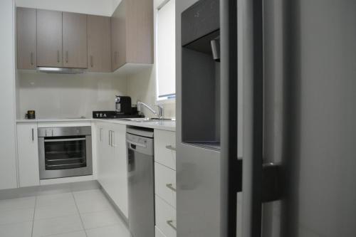 Biloela潶文比洛公寓的厨房配有白色橱柜和不锈钢用具