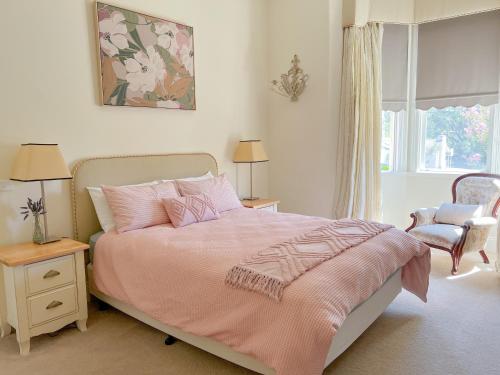 蒂默特The Monarch Tumut - Luxury in the valley的卧室配有粉红色的床和窗户。