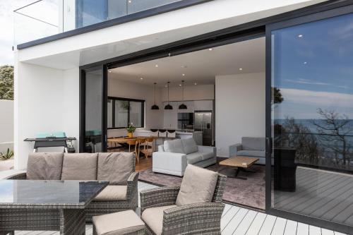 OakuraOakura Beach Front Apartments的开放式客厅和带滑动玻璃门的用餐室