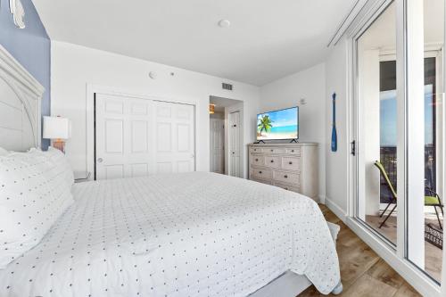 德斯坦9th floor 2BR 2 BATH King Suite Beach shuttle, heated pool!的白色卧室配有白色的床和电视