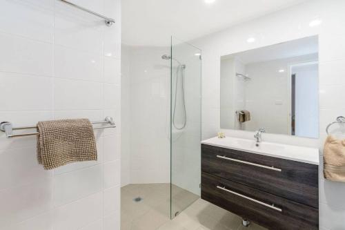 扬巴Pippi Beach Penthouse的一间带水槽和玻璃淋浴的浴室