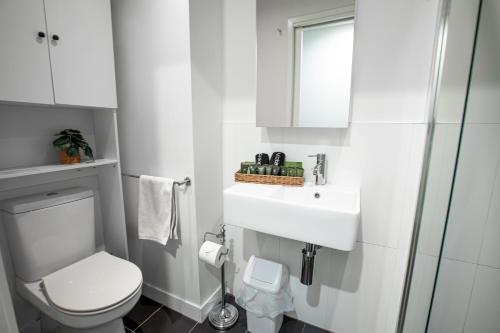 墨尔本‘Sunrise on Aura’ Apartment with stunning views.的白色的浴室设有卫生间和水槽。