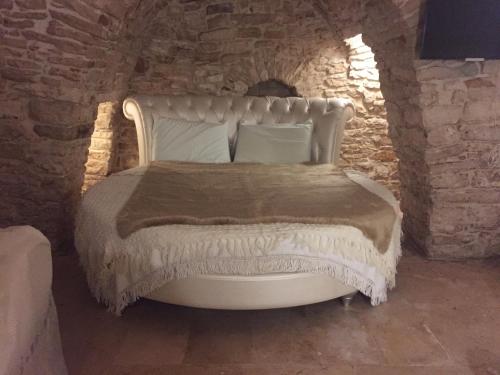 泰尔利齐Locus Amoenus Luxury rooms的卧室配有石墙内的白色床