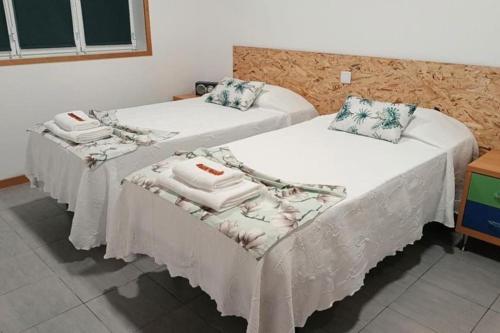 拉日什Cantinho do Cruzeiro Lajes的两张位于酒店客房的床,配有毛巾