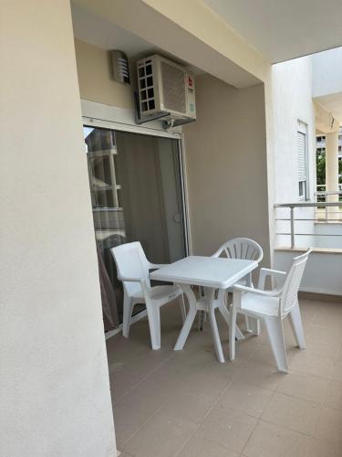 比耶拉New Comfortable Apartment in Bijela - Appart numéro 2的阳台上配有白色的桌椅和微波炉