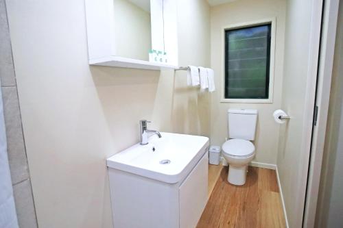 Lake Eacham钱伯斯野生动物雨林旅舍的浴室配有白色水槽和卫生间。