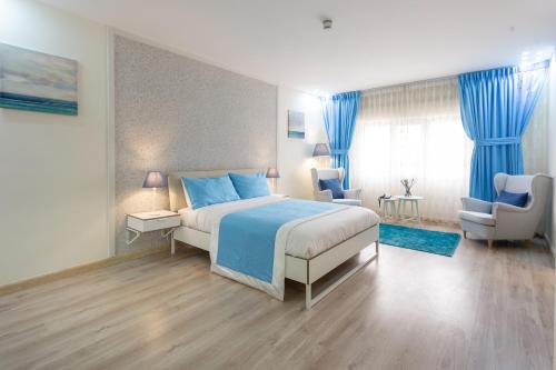 安曼Al Basem Hotel的一间卧室配有一张特大号床和蓝色窗帘